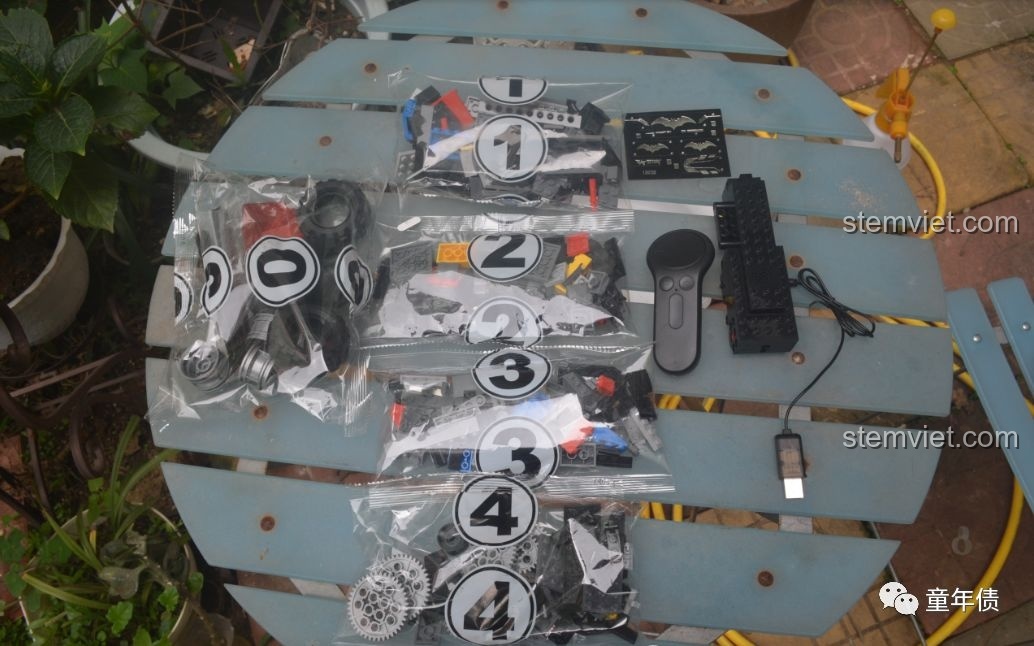 Toàn bộ chi tiết bên trong hộp Mould King 13020, bao gồm các túi gạch, động cơ, điều khiển và dây sạc USB.