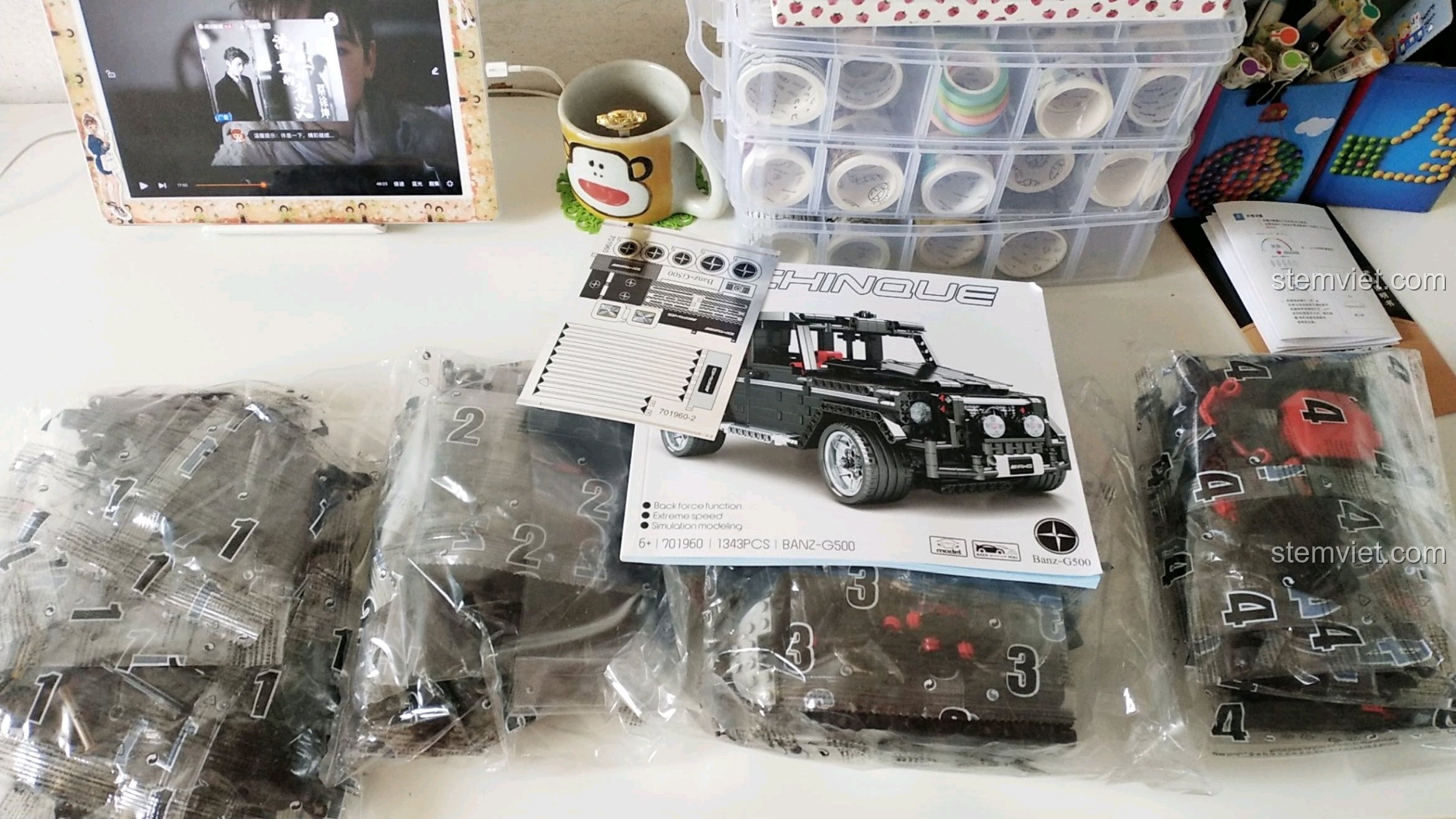 Các túi chi tiết nhựa, sách hướng dẫn và sticker của bộ SEMBO 701960 Xe G-Wagon được bày ra chuẩn bị cho quá trình lắp ráp.