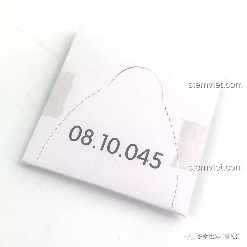 Một hộp giấy nhỏ màu trắng chứa cuộn dây cẩu, một chi tiết đặc biệt trong bộ QMAN 2806.