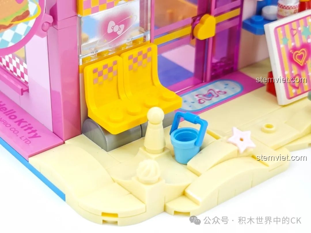 Cận cảnh chi tiết ghế ngồi và xô cát nhỏ bên ngoài Nhà hàng Hamburger Hello Kitty Bãi Biển TC2032.