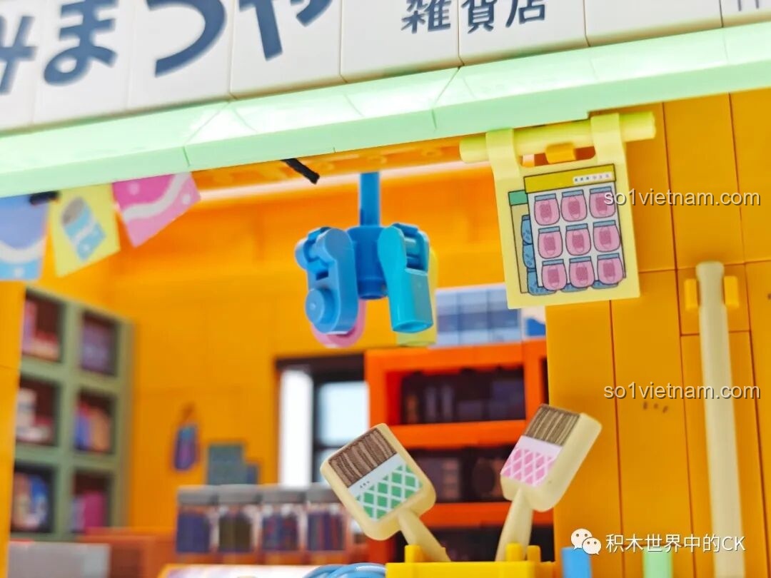 Cận cảnh các món đồ chơi và lịch treo tường bên dưới mái hiên của mô hình Tiệm Tạp Hóa Maruko Wekki.