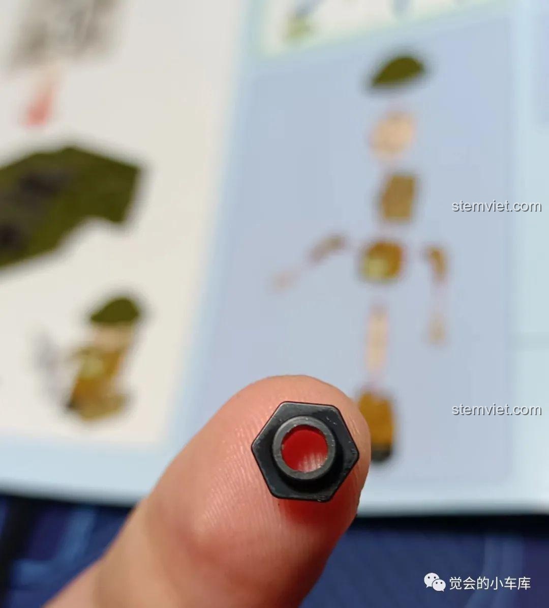 Chi tiết 1x1 hình lục giác độc đáo trong bộ lắp ráp QMAN 21023, trông giống như một con ốc vít.