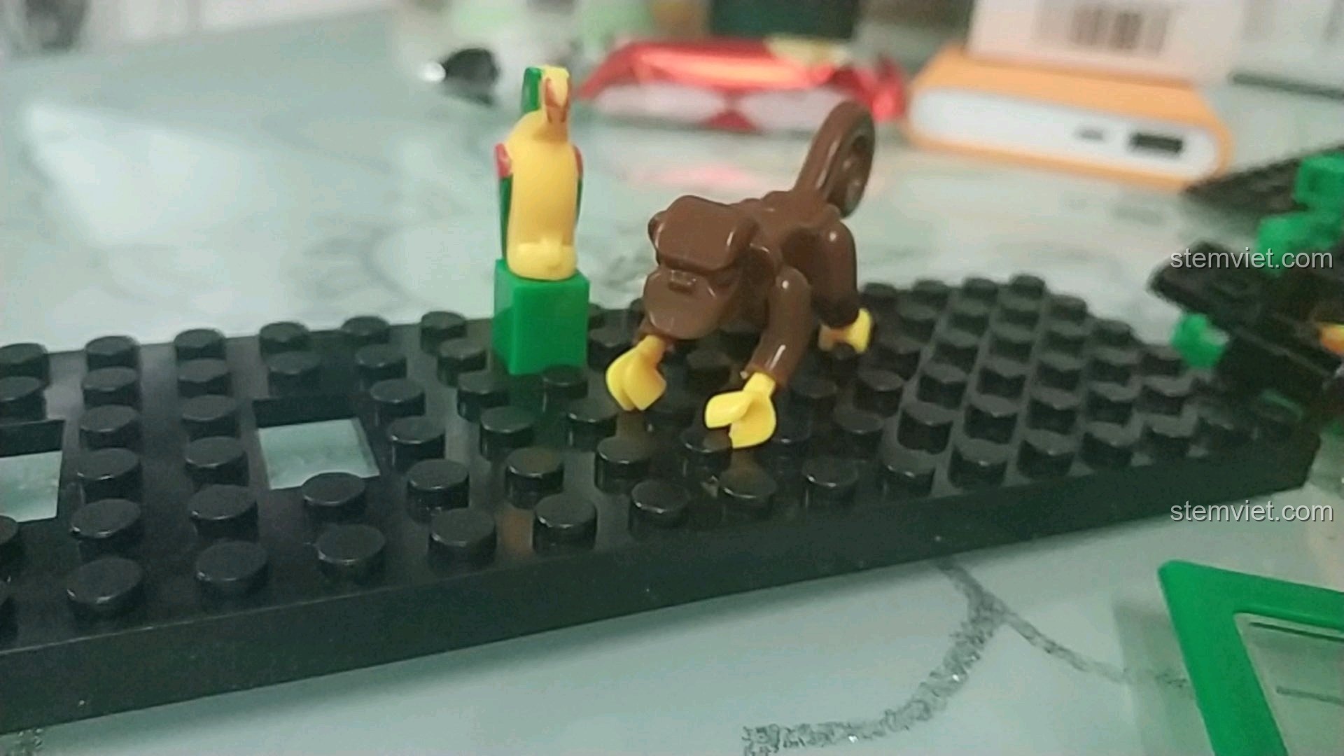 Các chi tiết động vật gồm khỉ và vẹt trong bộ đồ chơi lắp ráp Toa xe lửa Giáng Sinh 626.