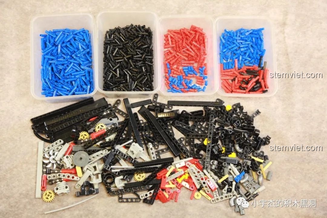 Các chi tiết từ túi số 1 được đổ ra, chủ yếu là các loại pin và trục màu xanh, đen, đỏ.