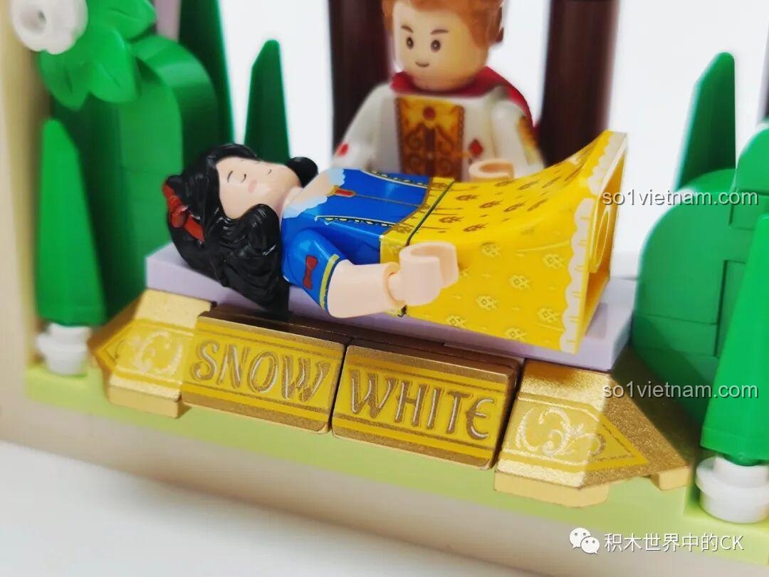 Cận cảnh chiếc giường của Nàng Bạch Tuyết với dòng chữ 'Snow White' được in trên các mảnh ghép màu vàng.