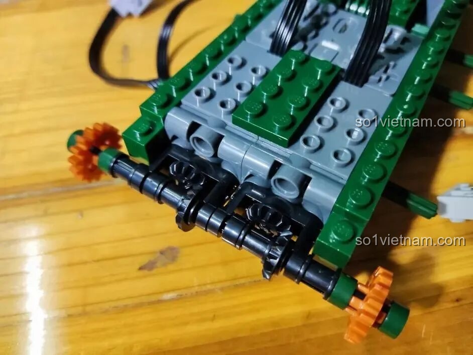 Cận cảnh hệ thống trục và bánh răng truyền động của xe tăng Sluban M38-B0850 đang được lắp ráp.