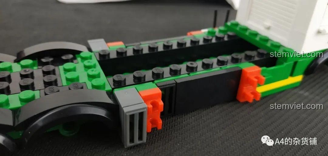 Chi tiết bên hông của xe tải chở rác Sluban B0780 với các cần gạt và khớp nối.