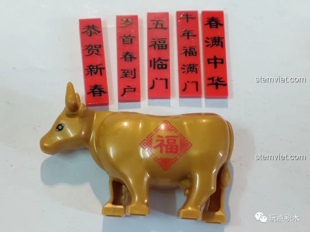 Chi tiết chú trâu vàng và các câu đối đỏ được in sắc nét trong bộ WOMA C9123, mang đậm không khí Tết.