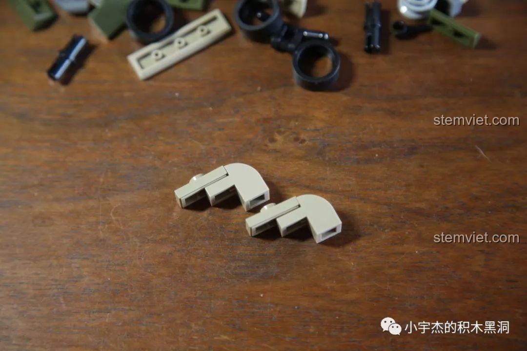 Hai chi tiết cong màu cát của bộ lắp ráp Mô hình quân đội WWII 101105, cho thấy một khe hở nhỏ khi lắp.