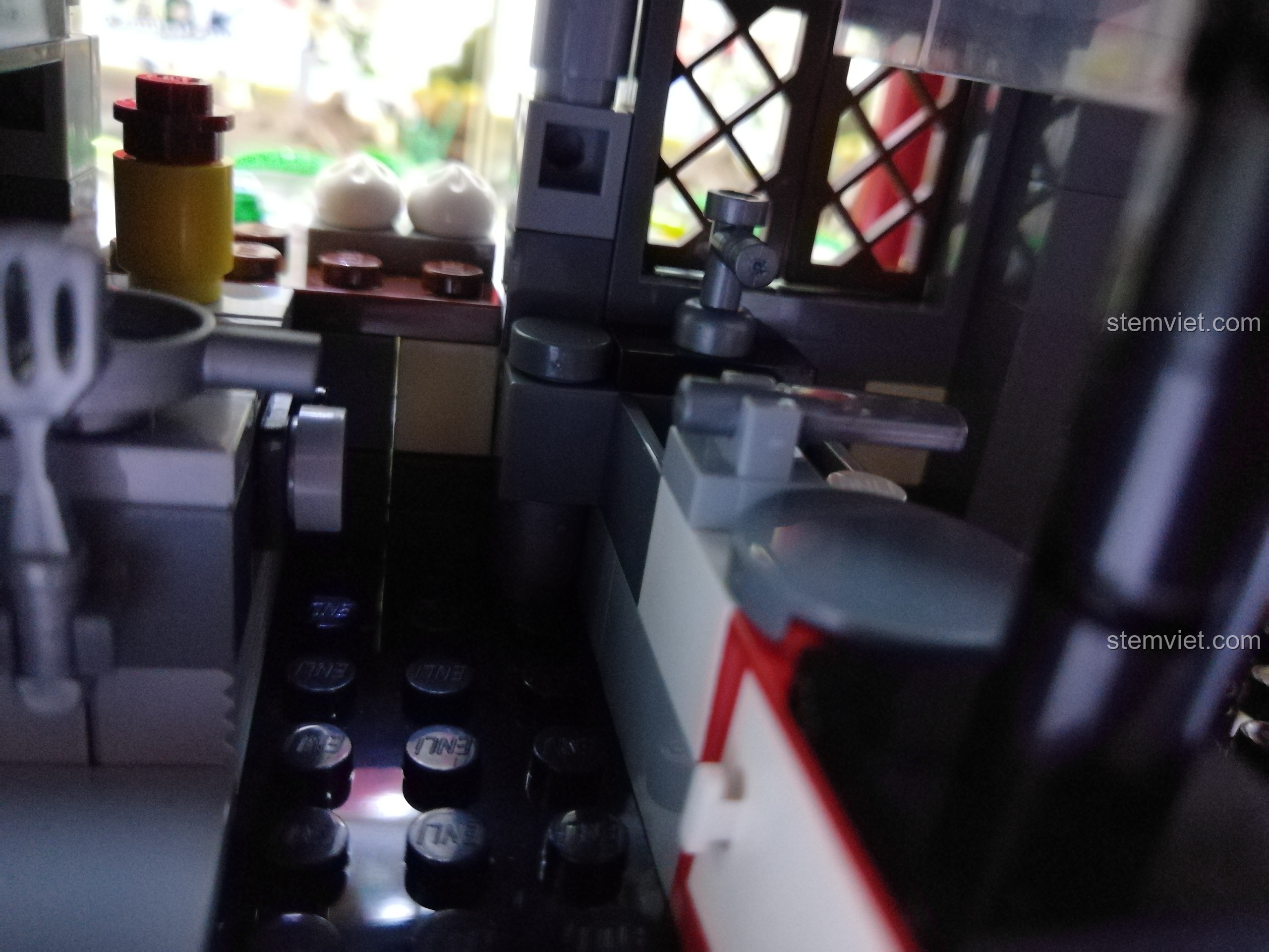 Góc nhìn chi tiết khu vực bếp của nhà hàng QMAN 1137, bao gồm bồn rửa, bếp và dụng cụ.