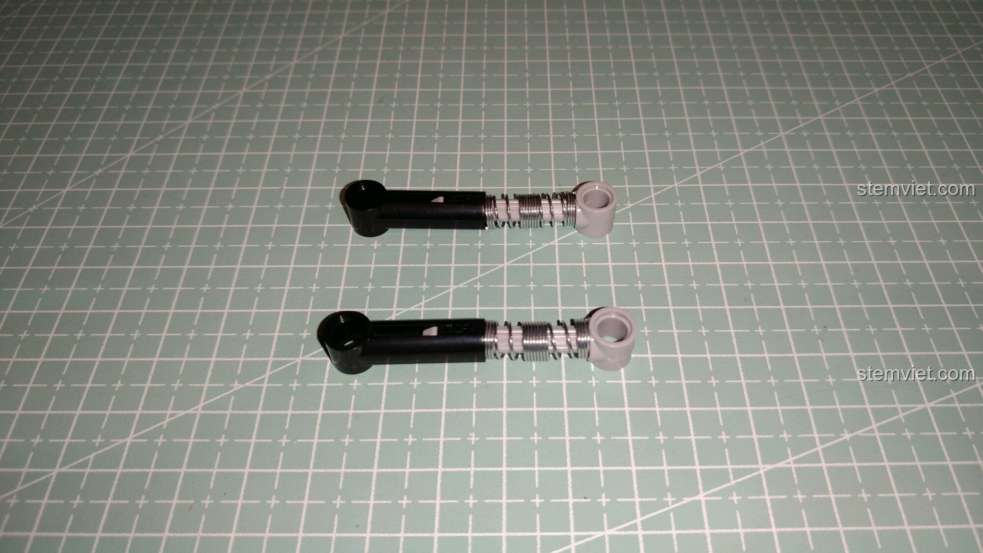 Hai chi tiết lò xo cứng trong bộ xếp hình Khẩu súng tiểu liên MP5 cho con trai 8 tuổi, dùng cho các cơ chế cơ học.