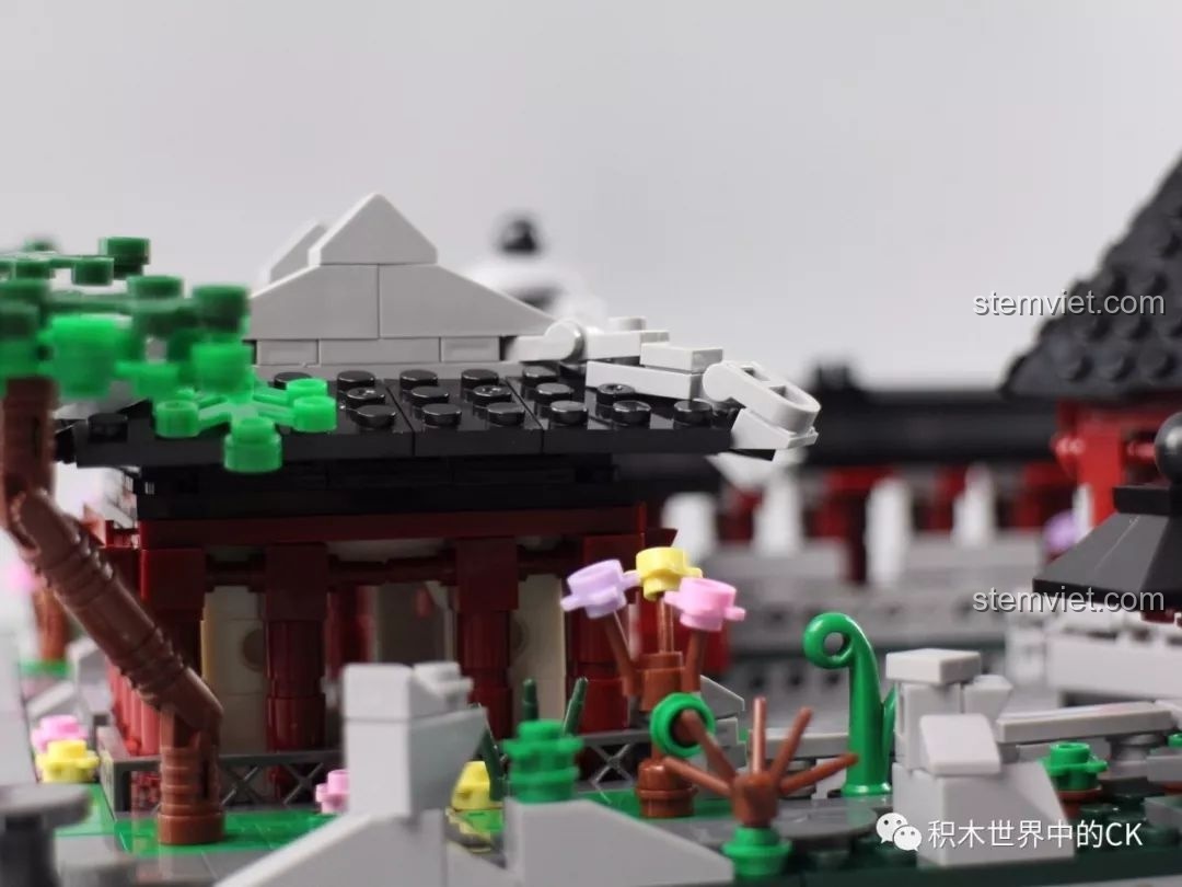 Ảnh chụp cận cảnh chi tiết mái đình cong và cây xanh trong bộ lắp ráp Vườn Tô Châu Xingbao.