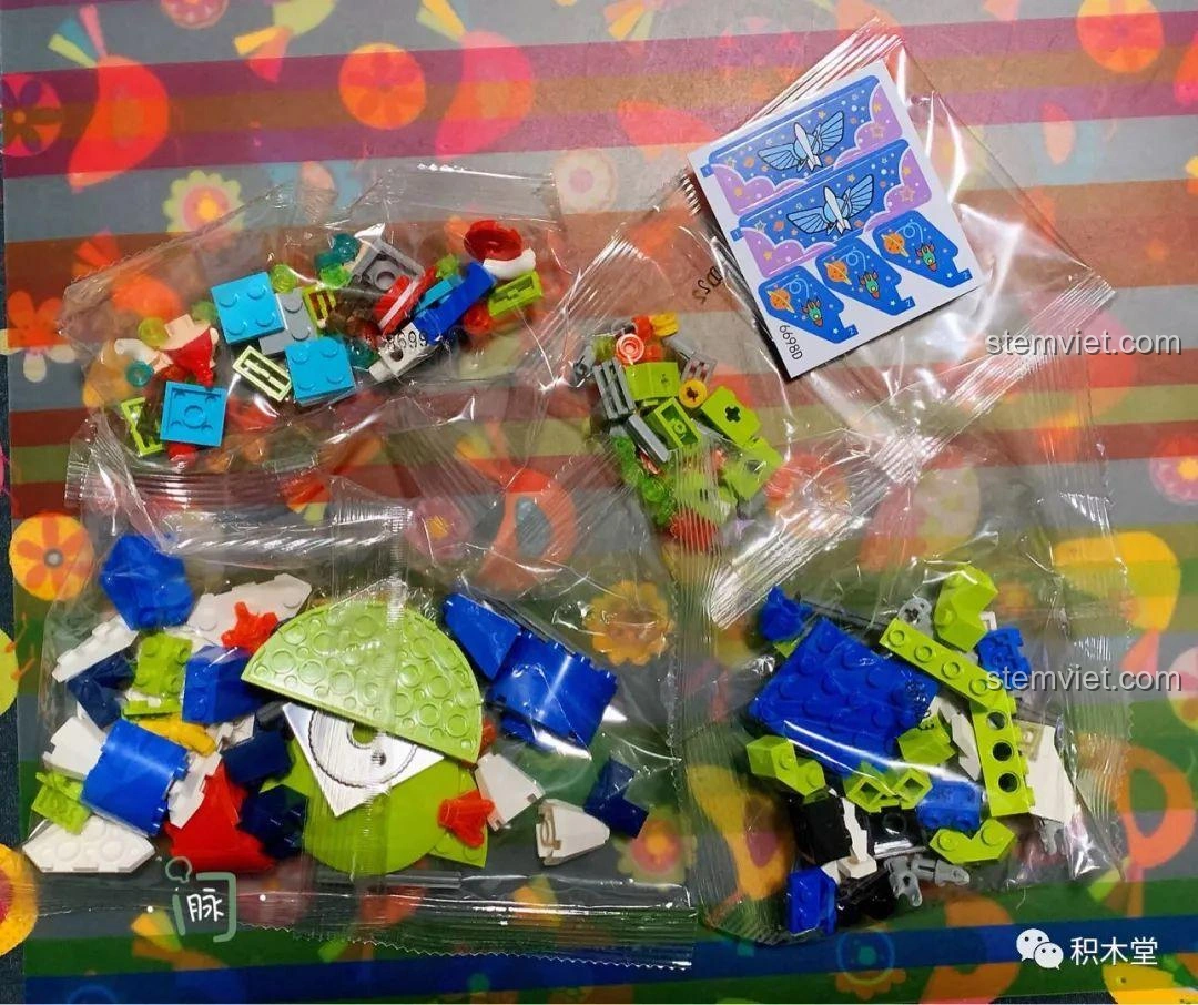 Các túi mảnh ghép của bộ lắp ráp Tàu Lượn Trên Không Của Jessie, với nhiều chi tiết màu xanh dương, xanh lá, đỏ và các mảnh in hình.