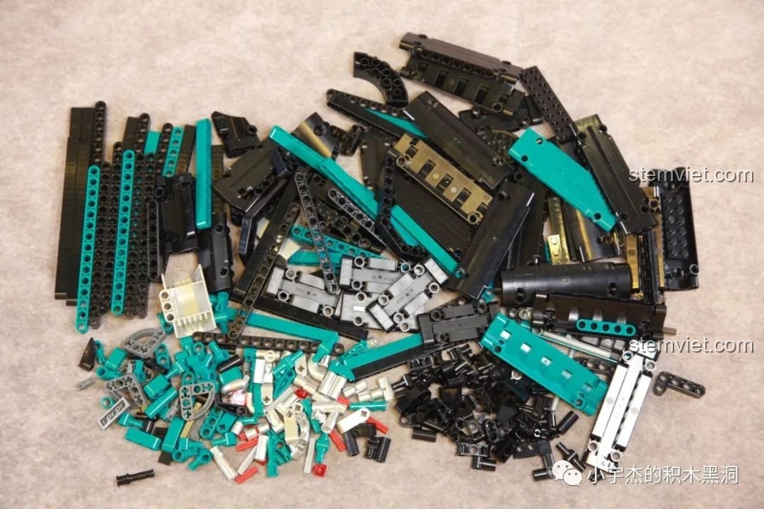 Các chi tiết từ túi số 3 được đổ ra, chủ yếu là các thanh và panel màu xanh ngọc và đen.