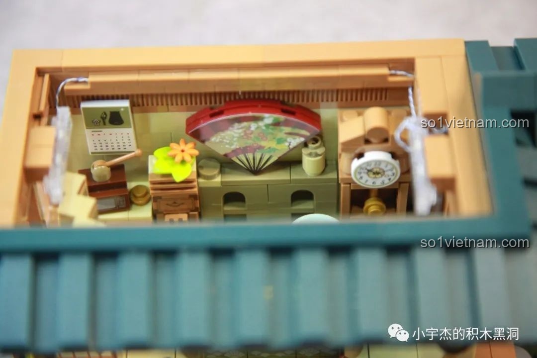Cận cảnh chi tiết nội thất tầng trệt của đồ chơi inbrixx 880018 Ngôi Nhà Nhật Bản Kumamon, với quạt giấy và đồng hồ.