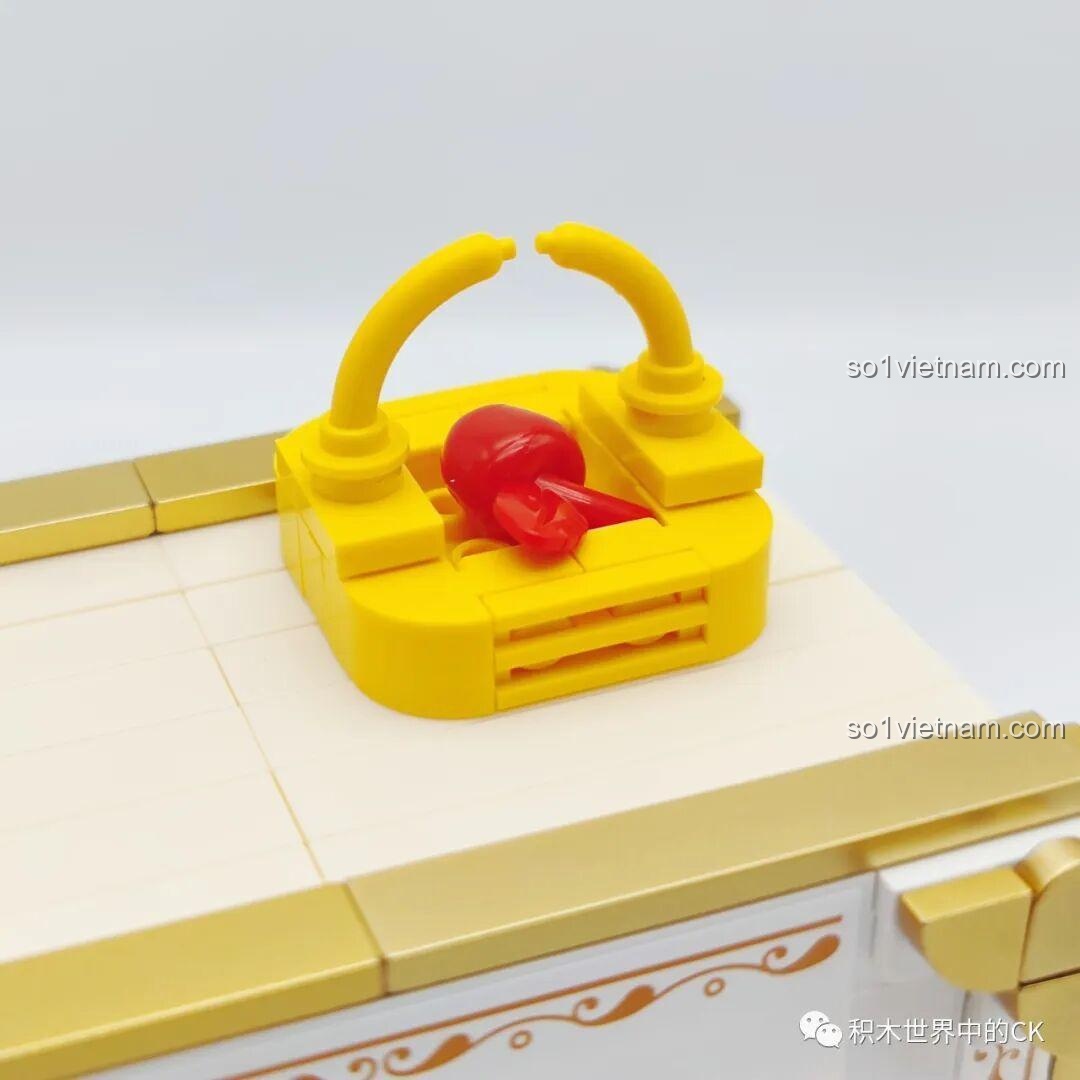 Chi tiết giỏ táo màu đỏ được đặt trên nóc sách mô hình Nàng Bạch Tuyết, một biểu tượng của câu chuyện.