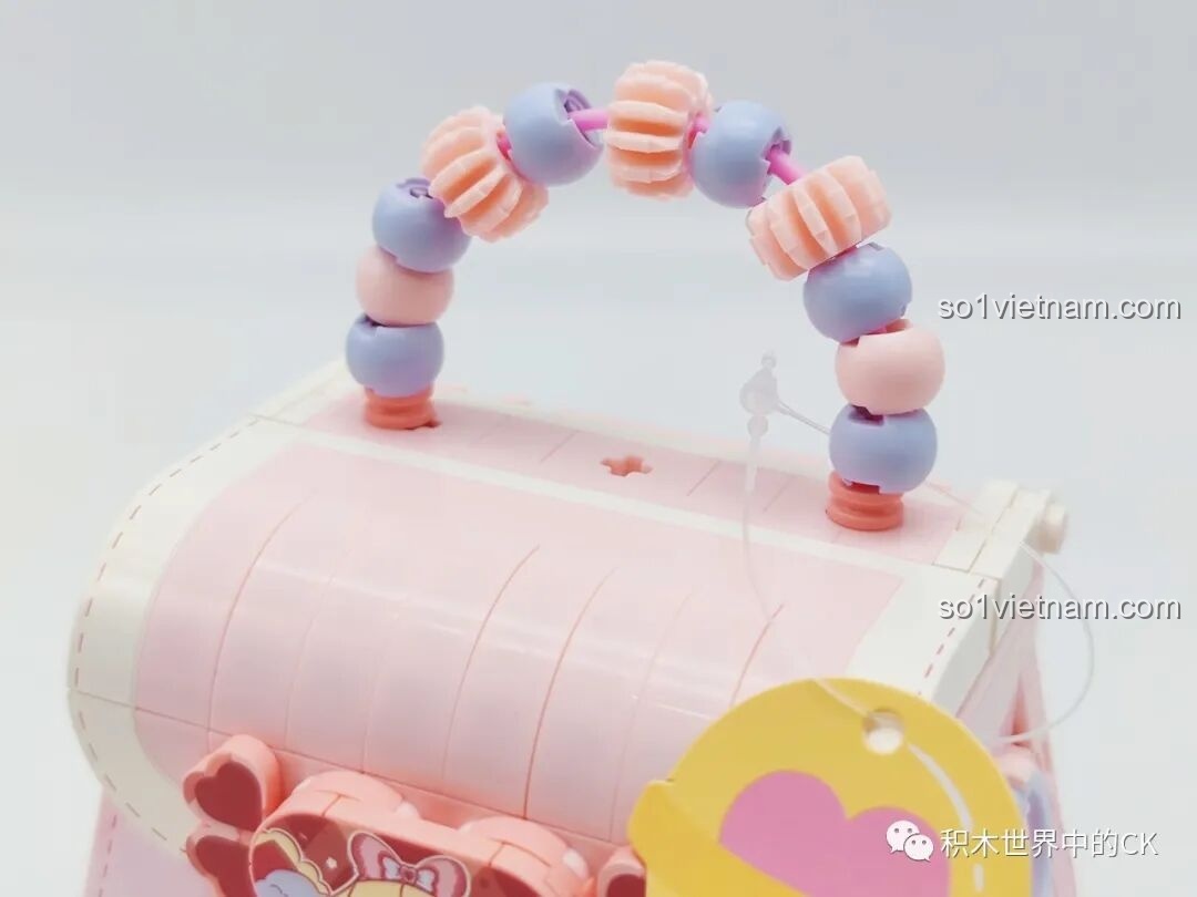 Cận cảnh quai xách được làm từ các hạt cườm nhựa màu hồng và tím của túi Wekki 516909.