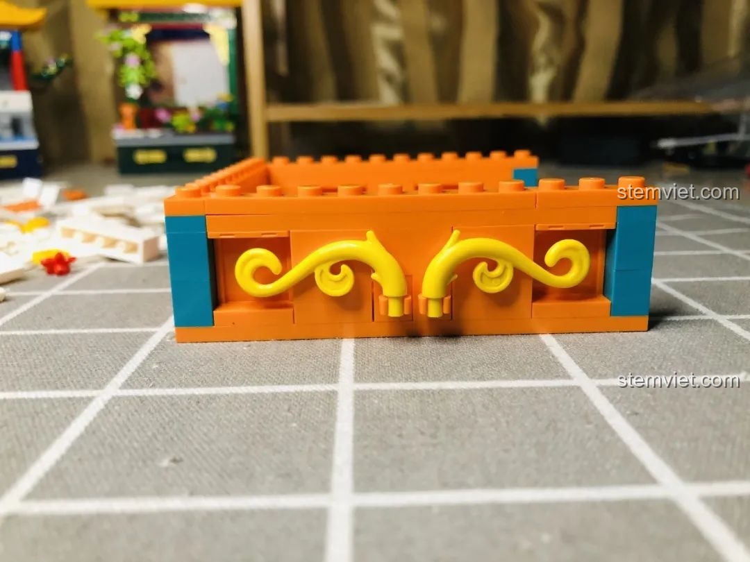 Cận cảnh các chi tiết trang trí màu vàng uốn lượn và xanh ngọc ở mặt ngoài phần đế của Wekki 506004 Cảnh Thu.