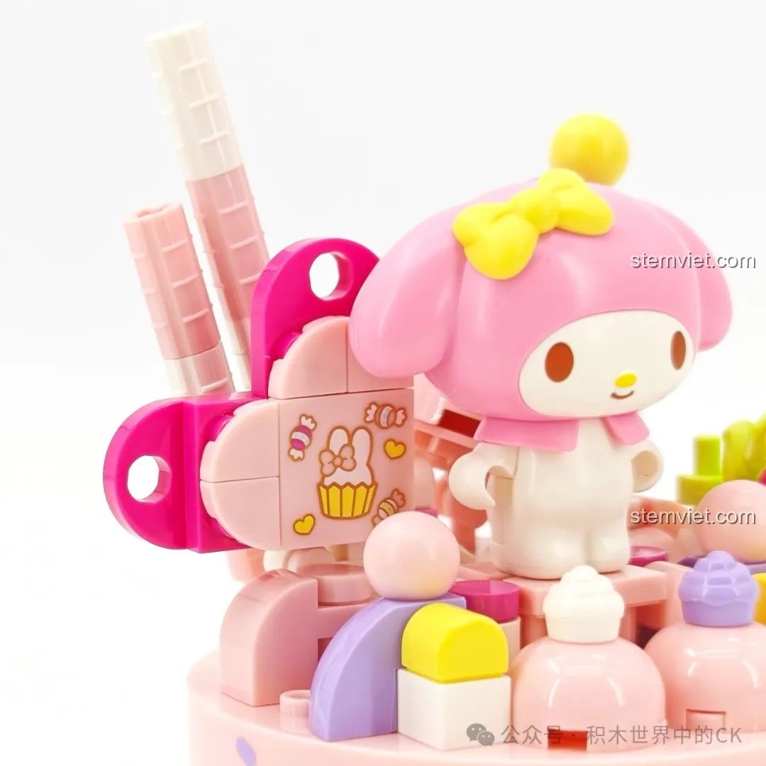 Chi tiết trang trí của mô hình My Melody, bao gồm các mảnh ghép hình son môi và bánh cupcake.