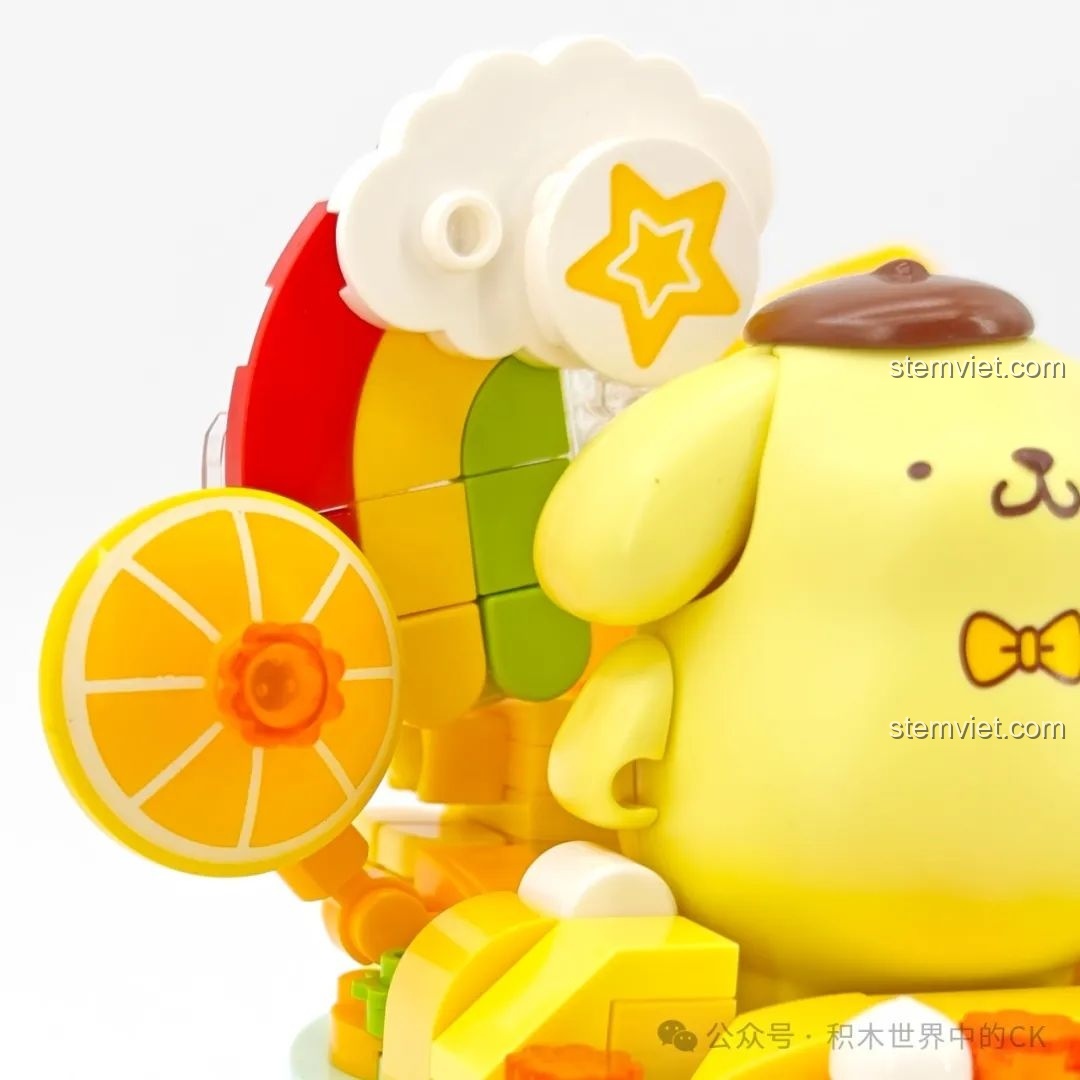 Chi tiết trang trí của mô hình Pompompurin, bao gồm các mảnh ghép hình cầu vồng và lát cam.