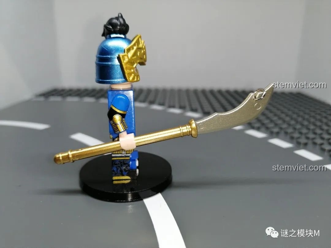 Góc nhìn từ bên cạnh của minifigure Trương Liêu, tập trung vào chi tiết thanh long đao mạ vàng.