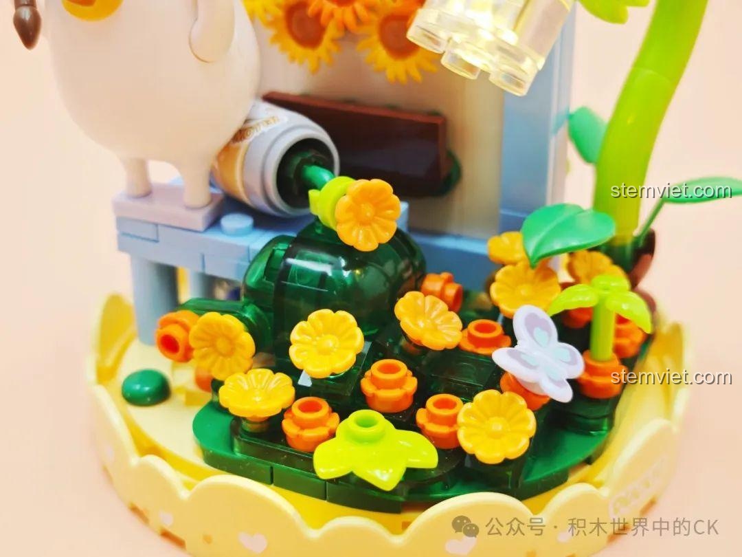 Chi tiết khu vườn hoa nhỏ với nhiều loại hoa và một con bướm trong bộ lắp ráp SEMBO 612024 Cọ Thần Nở Hoa.