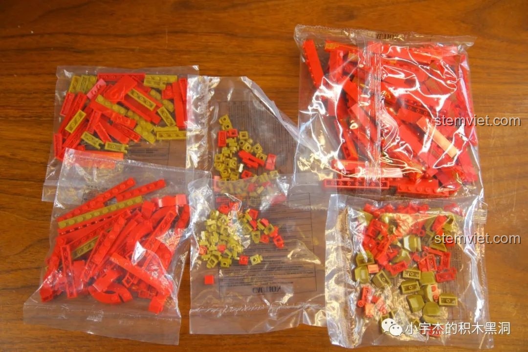 Các túi chi tiết cho bước lắp ráp thứ hai của bộ Hộp đựng đồ trang trí Tết WOMA, chủ yếu là các mảnh màu đỏ và vàng.