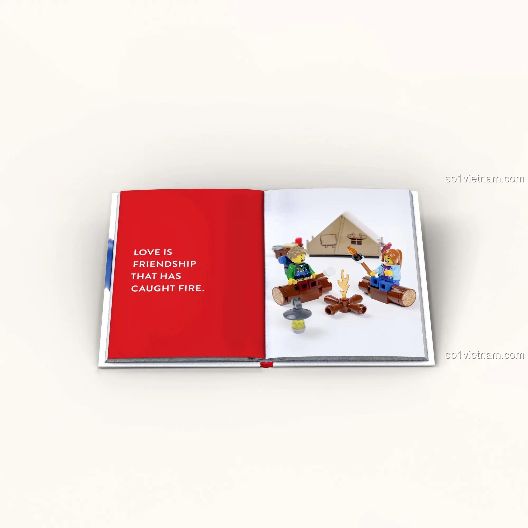 Sách truyện tình yêu LEGO® 1452182315 Sách về minifigures LEGO® 82315, trang sách mở với hai minifigure cắm trại bên lửa, kèm câu nói LOVE IS FRIENDSHIP THAT HAS CAUGHT FIRE., phù hợp cho thanh niên 12 tuổi, giá tốt.