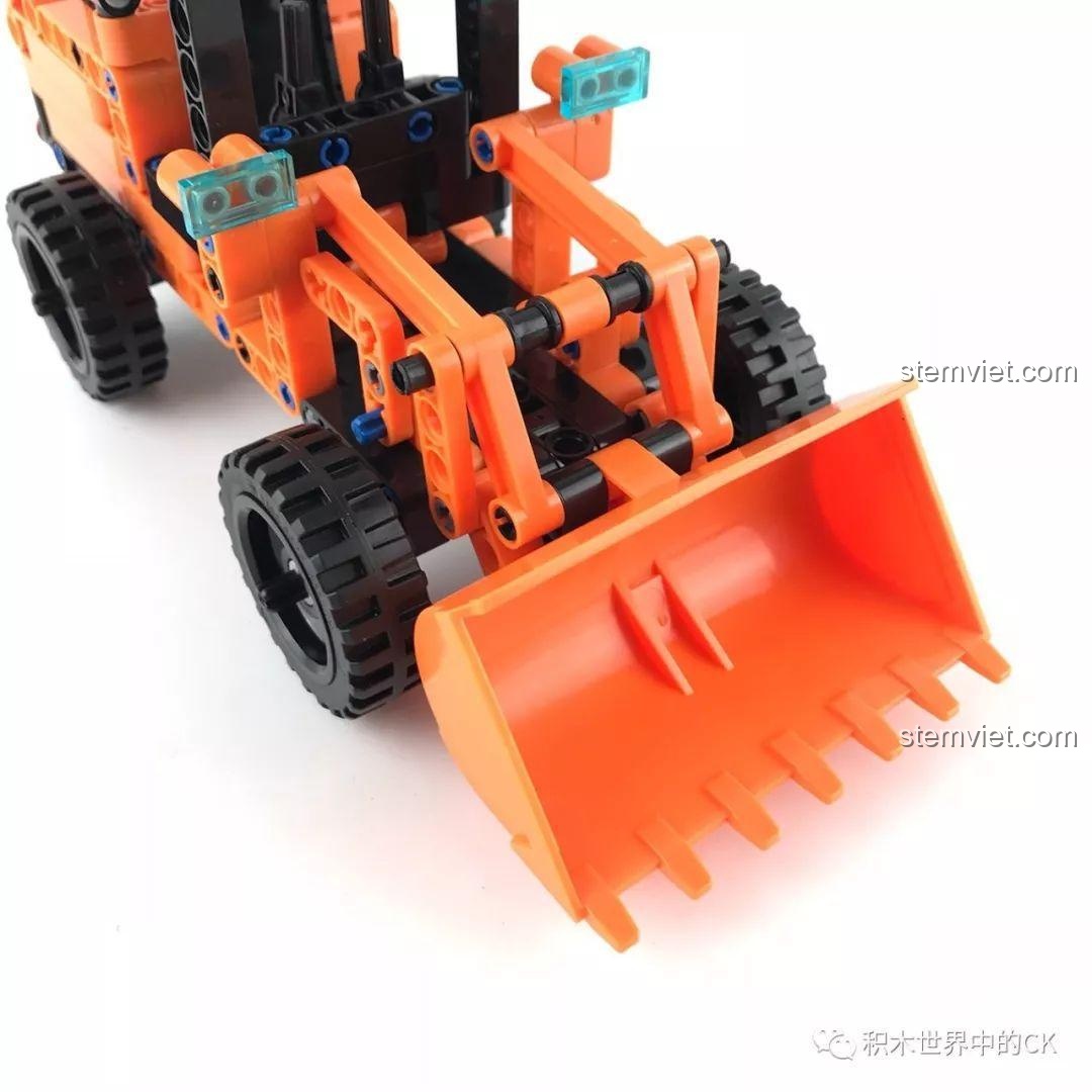 Mô hình xe xúc lật Winner 7086 đang nâng cao gàu múc, thể hiện chức năng của đồ chơi.