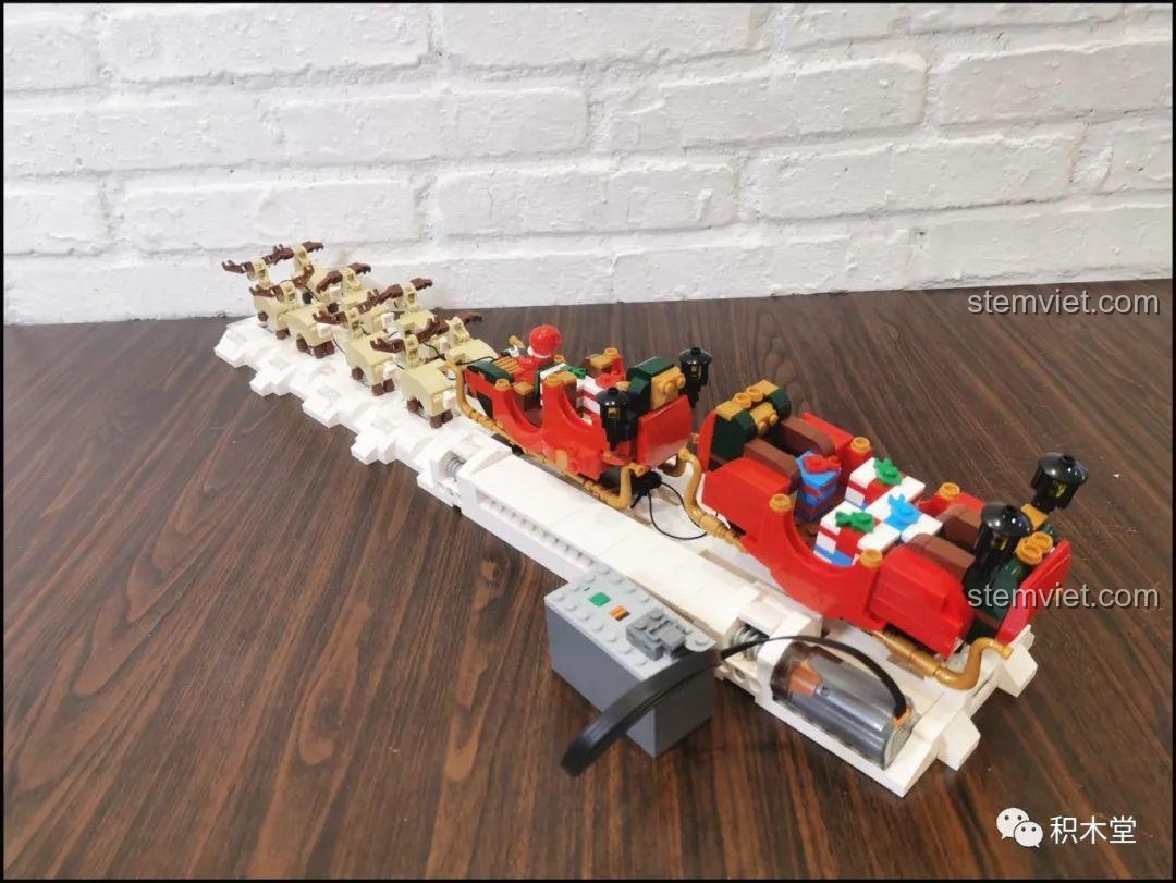 Mô hình Xe Trượt Tuyết Của Ông Già Noel đang hoạt động với động cơ, tạo ra chuyển động nhịp nhàng.