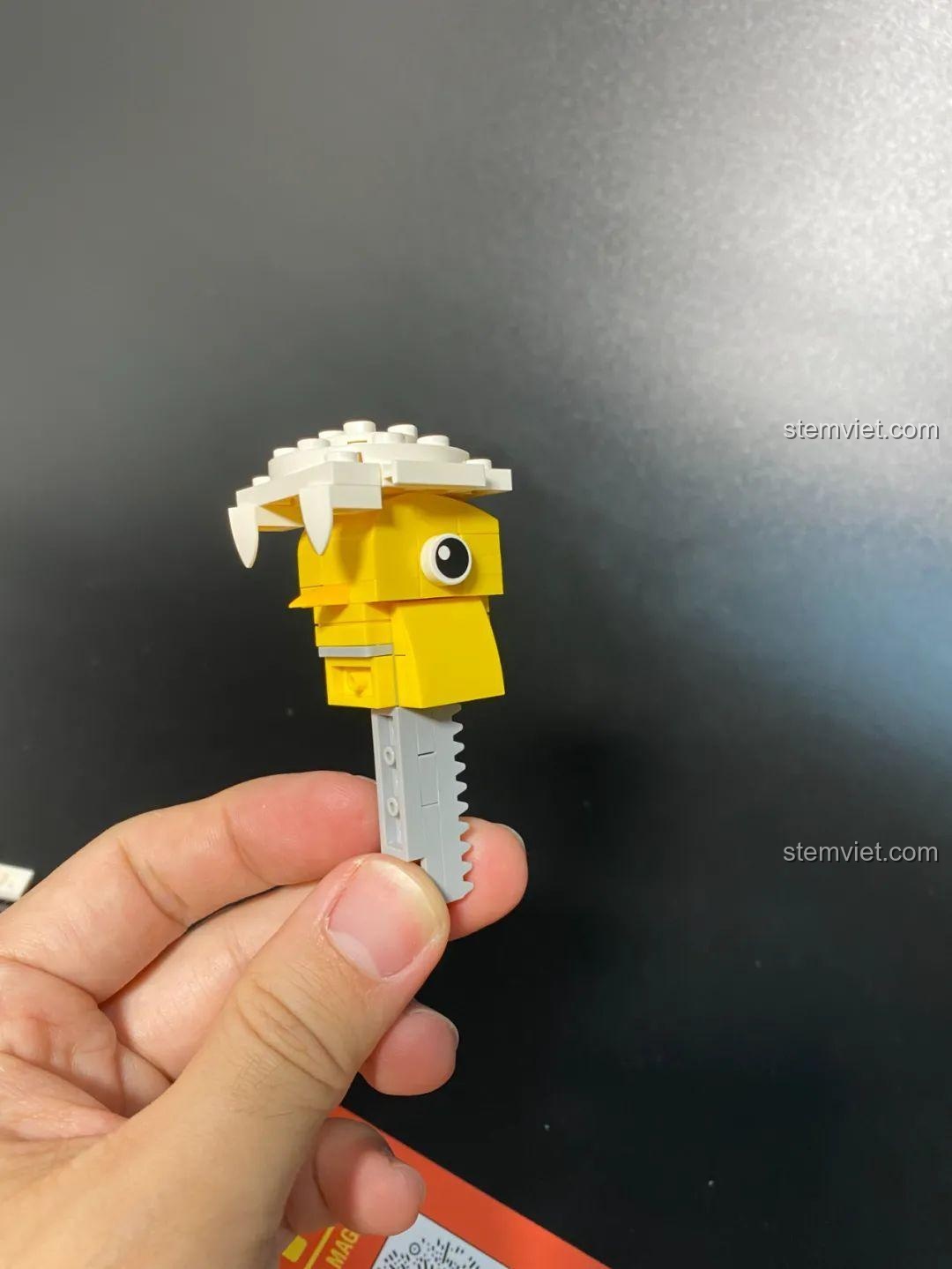 Phần đầu gà con màu vàng với cơ chế bánh răng, là trái tim của mô hình gà con nở vỏ trứng Cool Toys Trend 03.