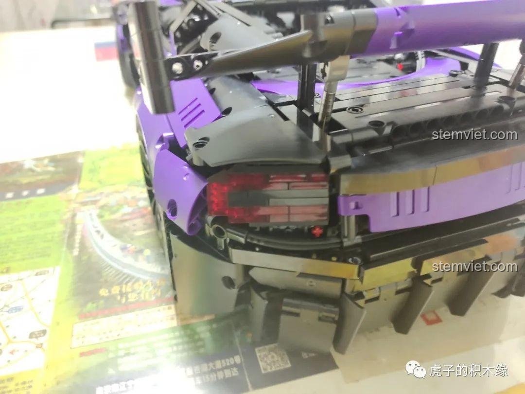 Cửa xe của mô hình Aston Martin Vantage GT3 KaCo Blocks C001 có thể mở rộng tối đa, để lộ nội thất bên trong với vô lăng và bảng điều khiển.