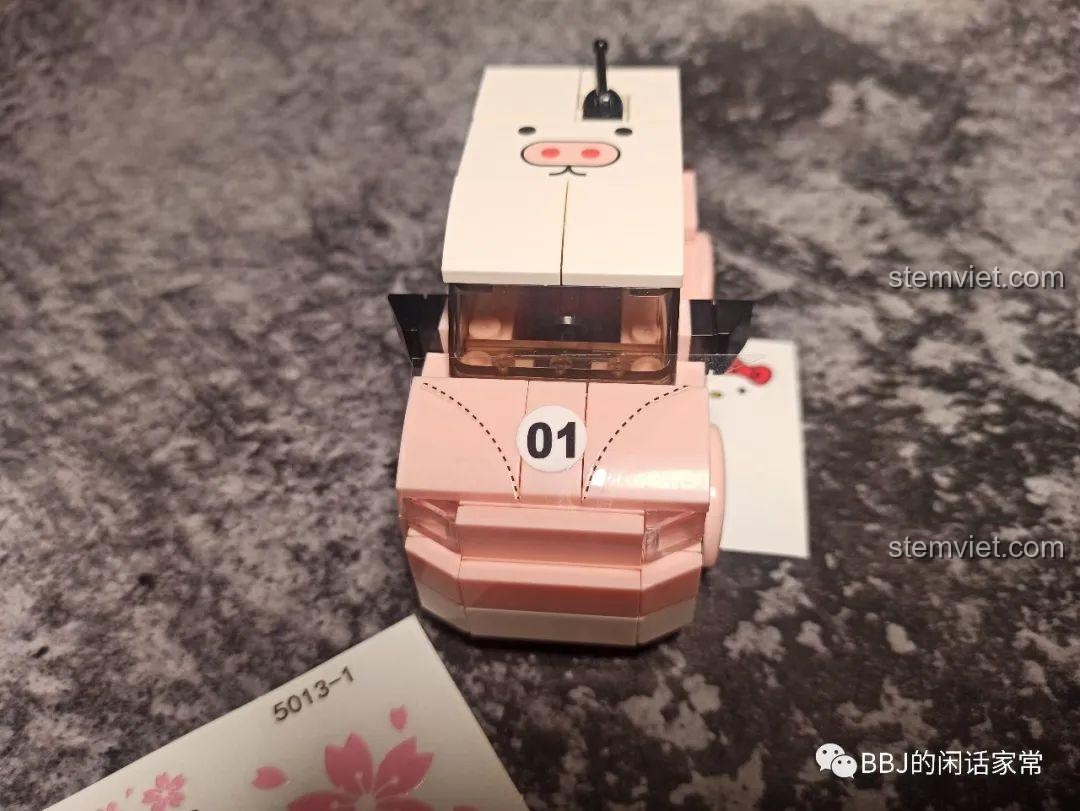 Quá trình dán sticker hình heo con lên nóc và mui xe của mô hình lắp ráp SY 5013 màu hồng.