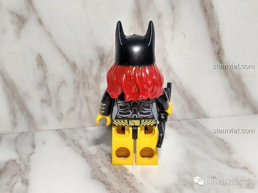 Mặt sau của minifigure Batgirl 1023, cho thấy mái tóc đỏ bên dưới mũ và chi tiết in trên lưng.