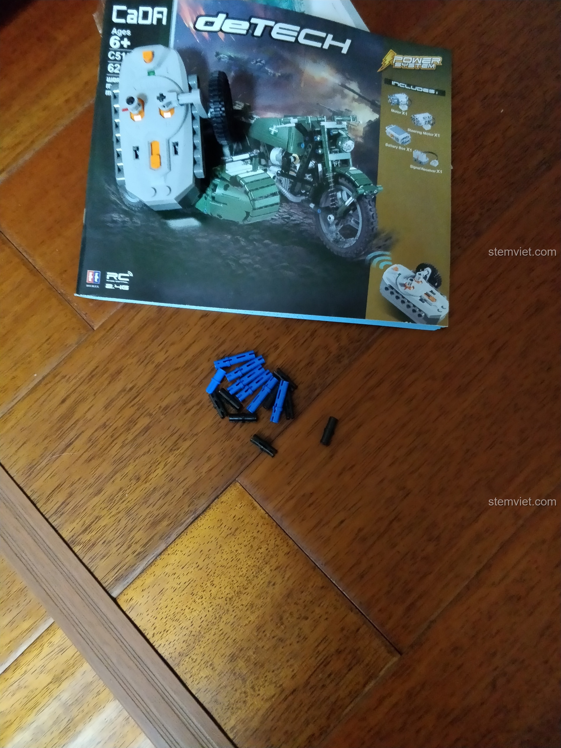 Các chi tiết thừa và bộ điều khiển từ xa của mô hình CaDA C51021 sau khi lắp ráp xong.