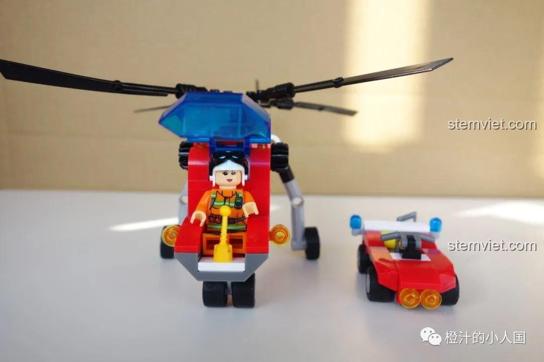 Đánh giá CAYI 2603 Trực thăng cứu hộ với minifigure phi công ngồi trong buồng lái và xe hỗ trợ bên cạnh.