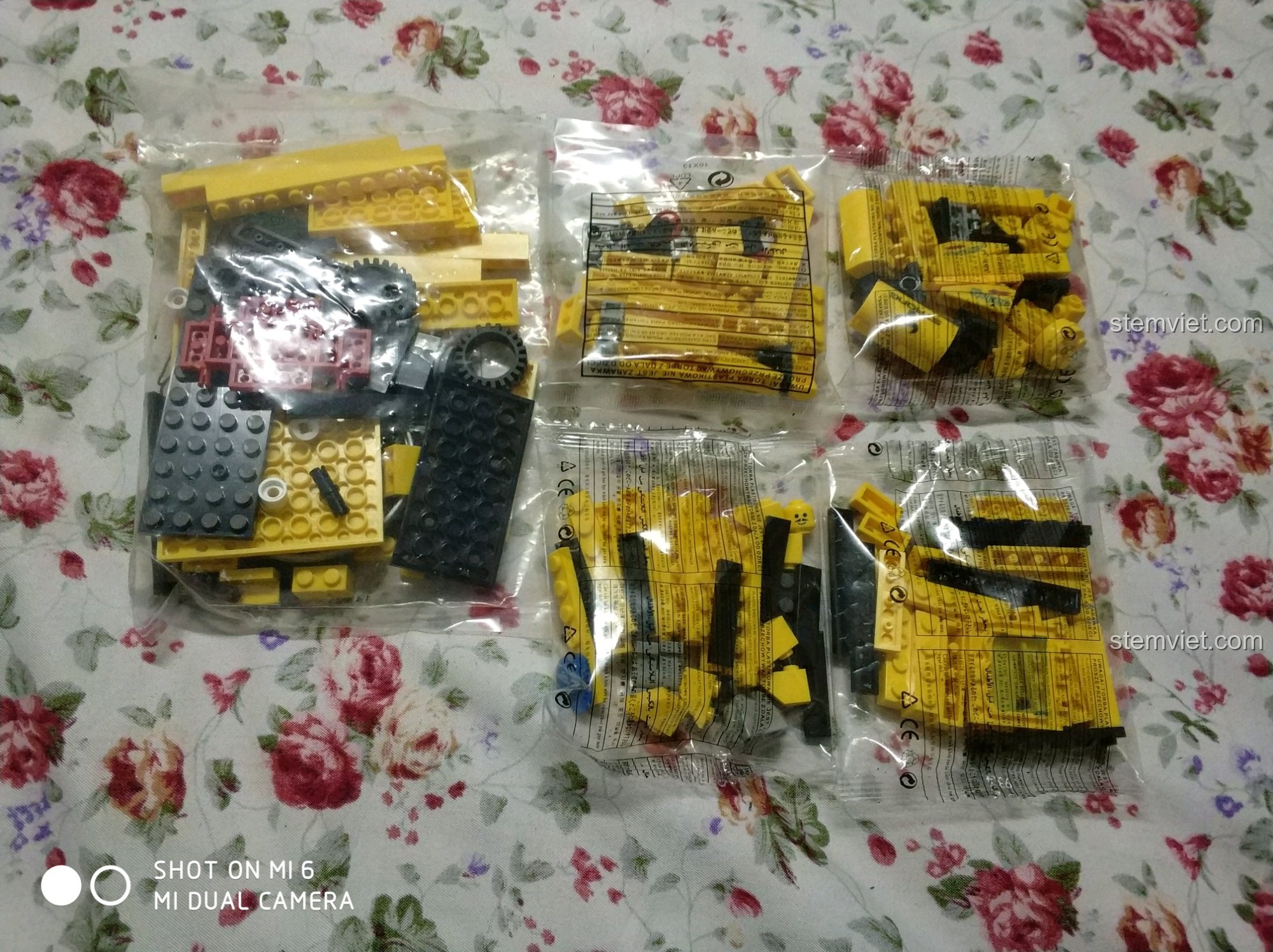 Các túi chi tiết bên trong hộp đồ chơi Enlighten 0493 Xe Nâng Hàng Hạng Nặng và Đua Mini, sẵn sàng cho việc lắp ráp.