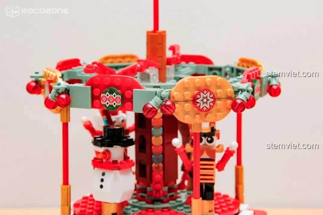 Chi tiết trang trí trên vòng quay của Hộp nhạc Giáng Sinh Xoay Tự Động JAKI JK1365, với các bóng đèn nhỏ màu đỏ và họa tiết Giáng Sinh.