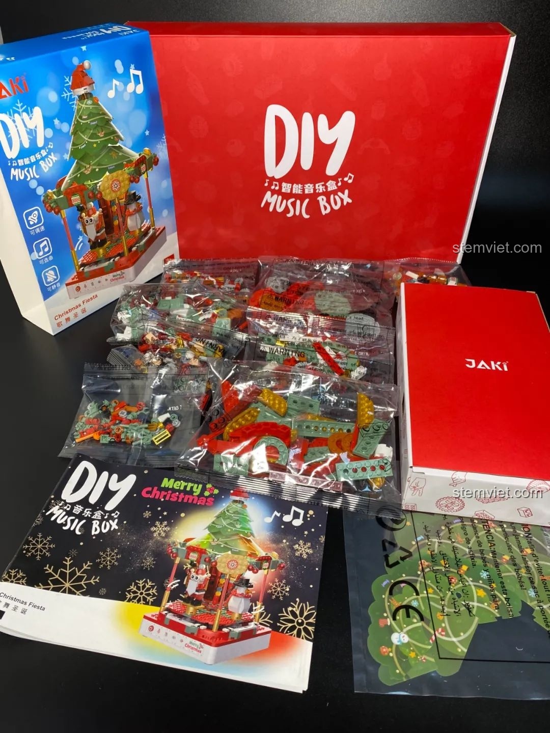 Toàn bộ các mảnh ghép và phụ kiện bên trong hộp đồ chơi Hộp nhạc Giáng Sinh Xoay Tự Động JAKI JK1365 sau khi mở hộp. Đồ chơi lắp ráp Giáng Sinh có nhạc.
