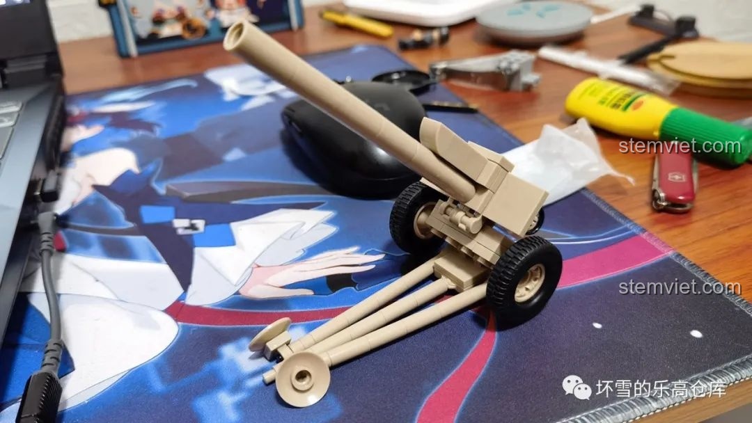 Mô hình pháo lắp ráp màu be đặt trên bàn làm việc, có thể là một mẫu pháo khác để so sánh. Đánh giá QUANGUAN 078 Vũ khí quân sự Liên Xô.