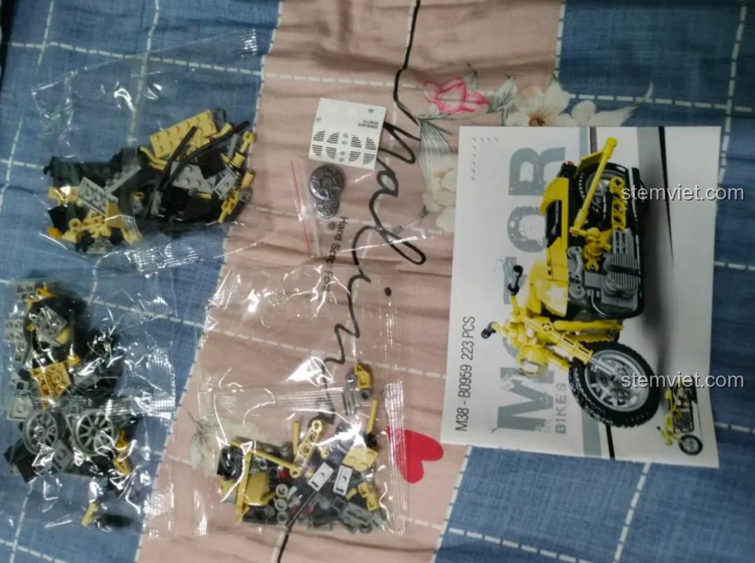 Các túi mảnh ghép và sách hướng dẫn của bộ đồ chơi lắp ráp Sluban M38-B0959 Mô tô R75, sẵn sàng cho bé khám phá.