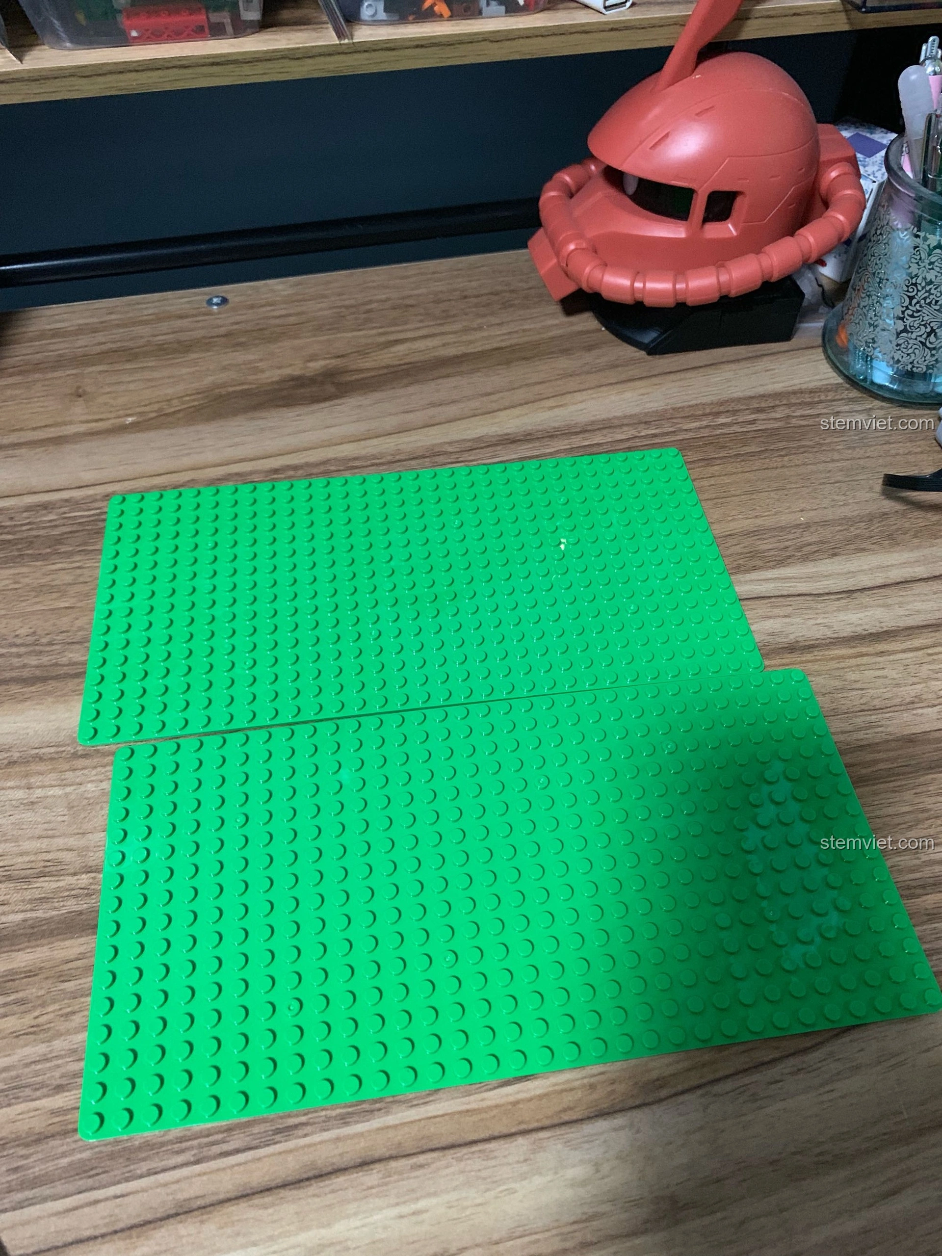 Hai tấm đế màu xanh lá cây được sử dụng làm nền cho bộ lắp ghép WANGE 6310 Quán Cà Phê Vườn, chuẩn bị cho việc xây dựng.