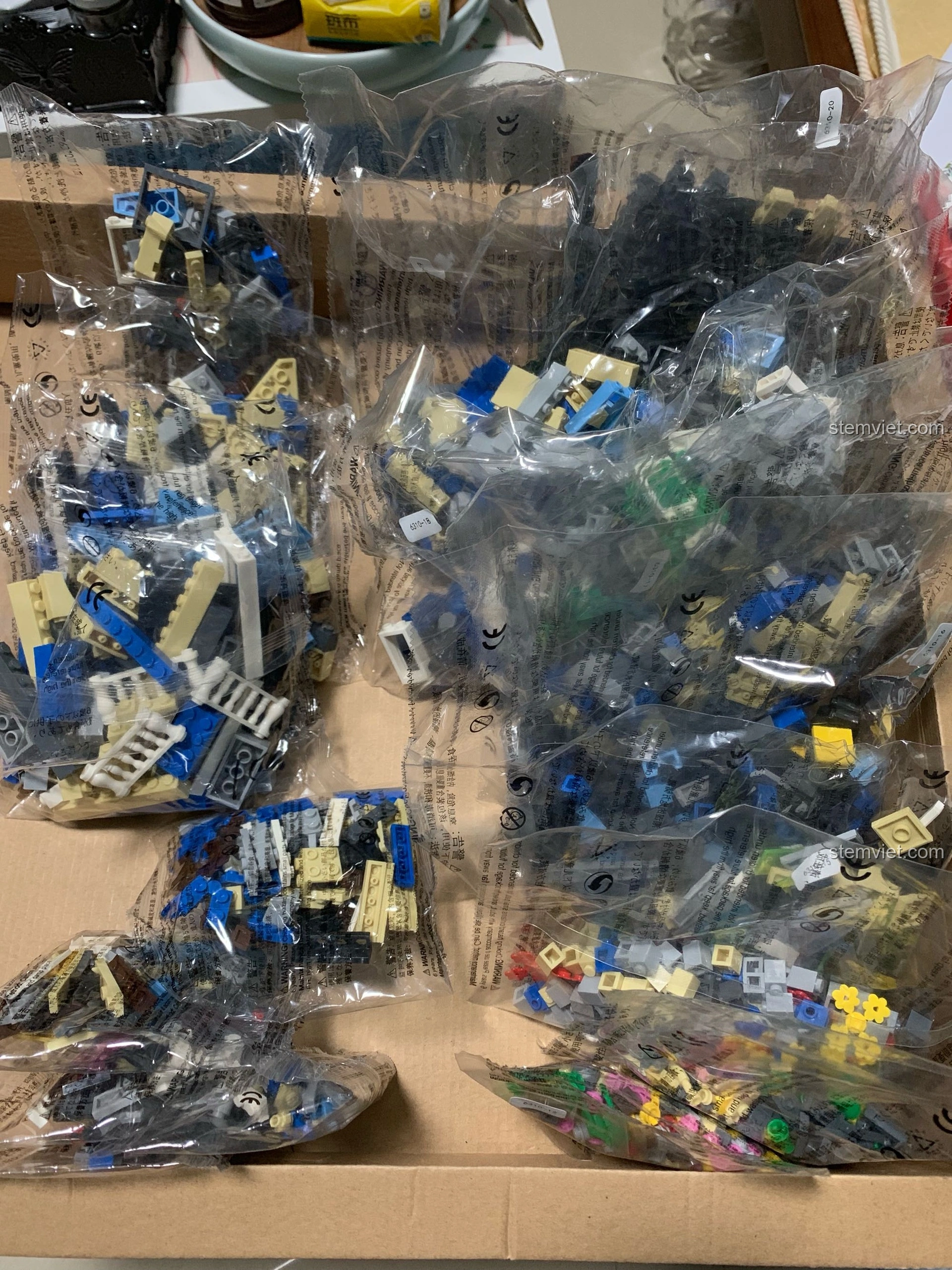 Các túi chi tiết được phân loại của bộ lắp ghép WANGE 6310 Quán Cà Phê Vườn, sẵn sàng cho quá trình lắp ráp.