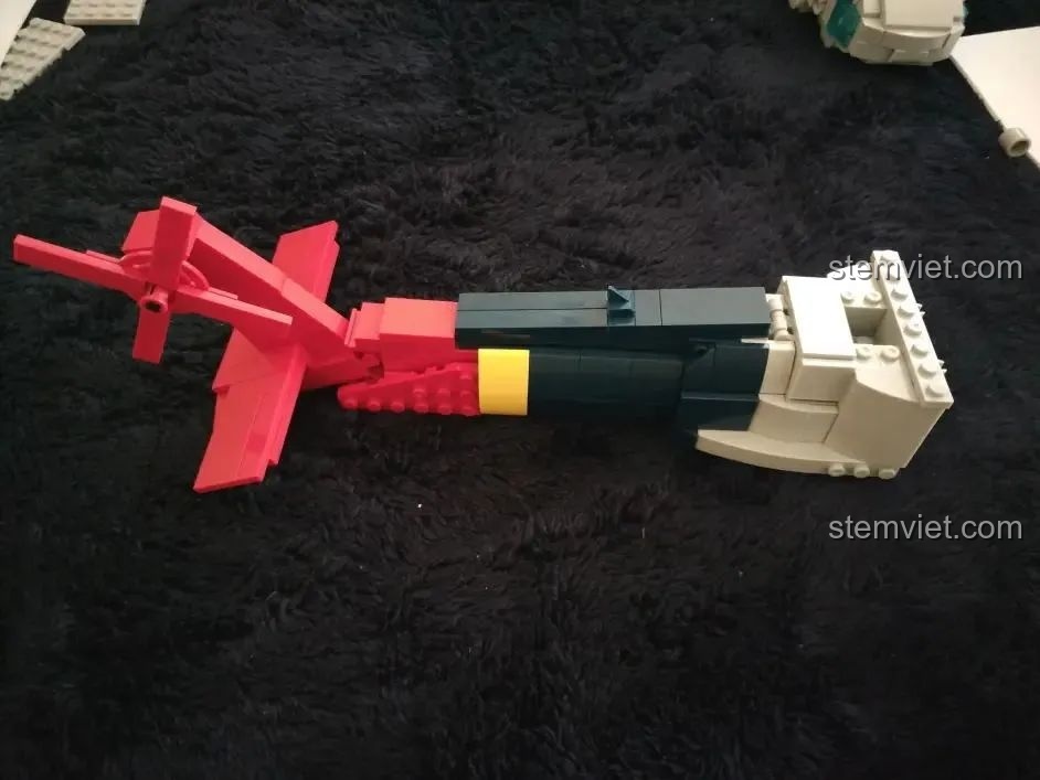 Lắp ráp phần đuôi của mô hình Chim Ưng Đen UH-60 WOMA 897 với các chi tiết màu đỏ, đen và vàng.