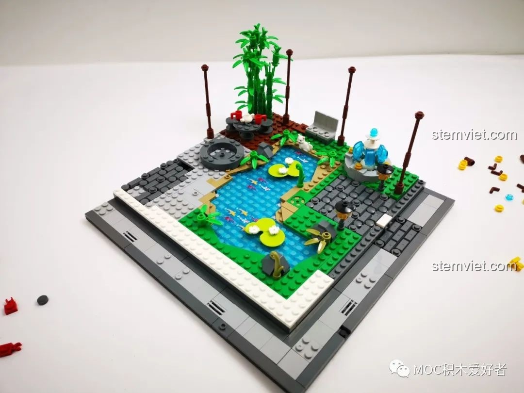 Thêm các chi tiết trang trí như bụi tre, hoa súng vào mô hình vườn cổ trang WOMA 9123, làm khu vườn thêm sống động.