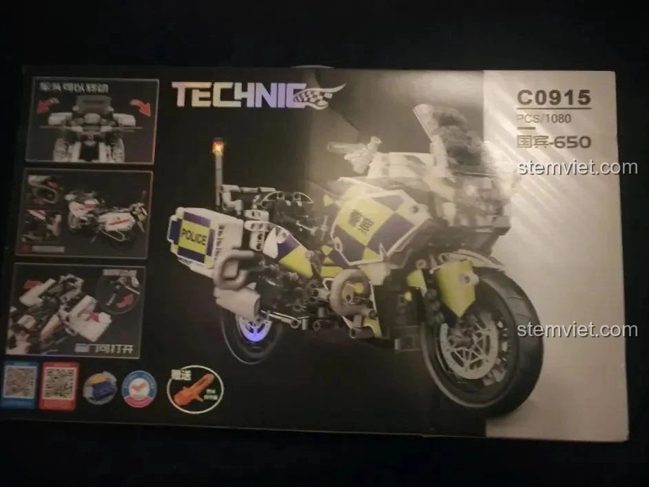 Mặt sau hộp đồ chơi lắp ráp WOMA C0915 Xe mô tô cảnh sát Quốc宾-650, hiển thị phiên bản màu vàng xanh và các tính năng.