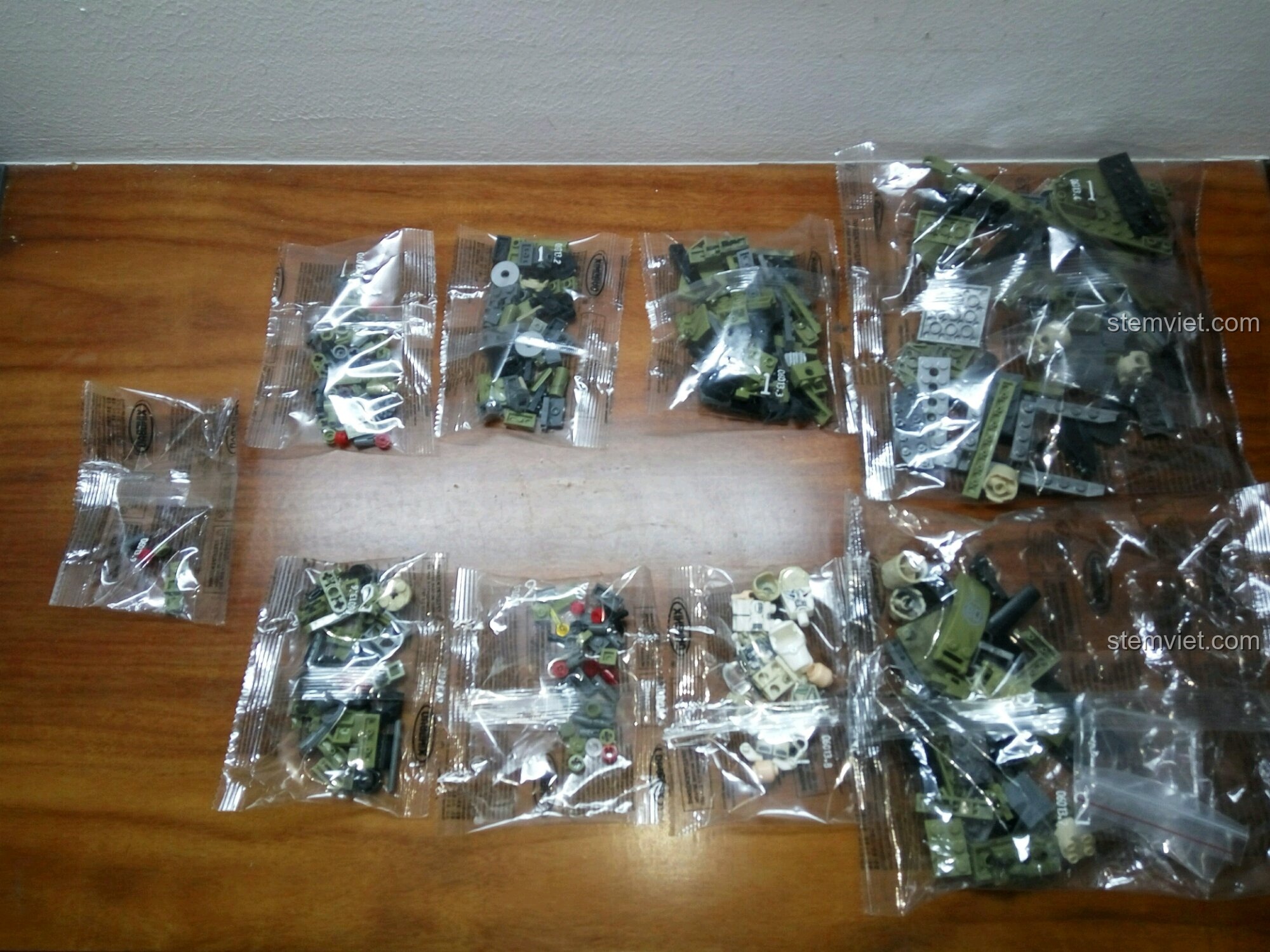 Các túi mảnh ghép của bộ lắp ráp Trực Thăng Quân Sự XB-06013 Xingbao được phân loại rõ ràng trên bàn gỗ.