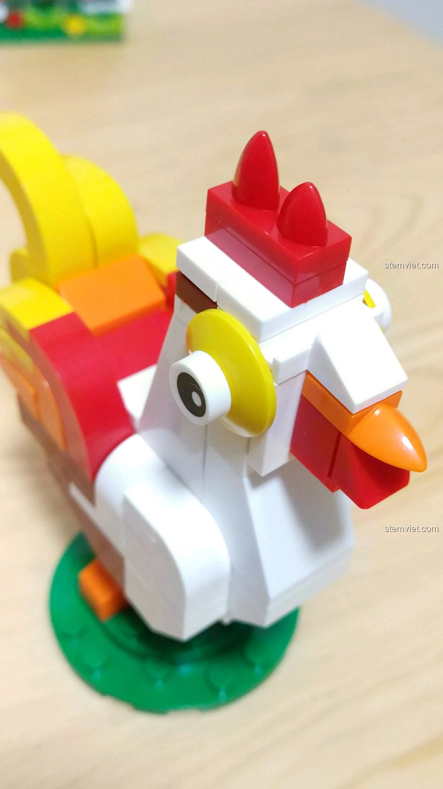 Cận cảnh khuôn mặt Gà Dậu với đôi mắt to tròn, mỏ vàng và mào đỏ, thể hiện sự đáng yêu của mô hình.