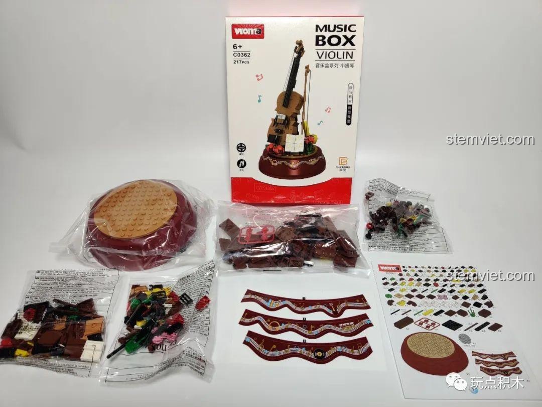 Trọn bộ sản phẩm WOMA C0362 Violin khi mở hộp, gồm các chi tiết màu nâu, đế nhạc đỏ và sách hướng dẫn.
