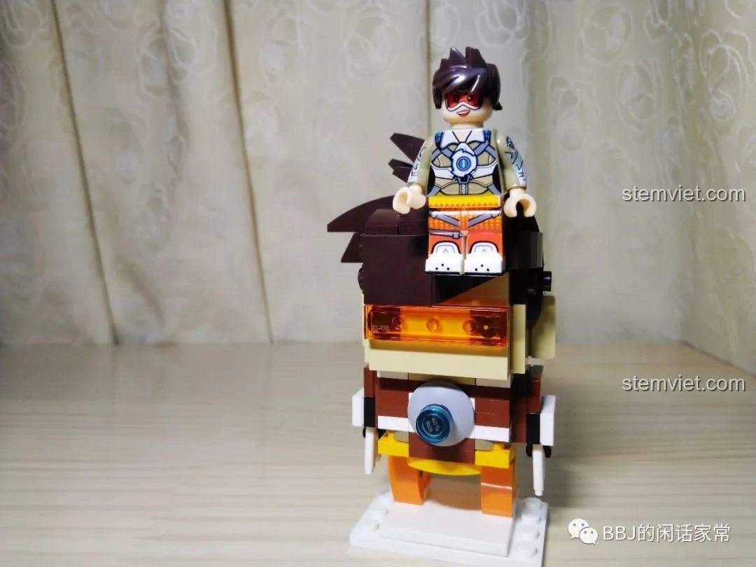 Một minifigure Tracer nhỏ đặt trên đầu mô hình BrickHeadz Tracer Decool 6852, tạo sự so sánh thú vị về kích thước.